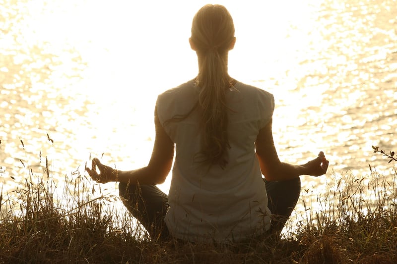 Woman practicing breathing exercise at sunset